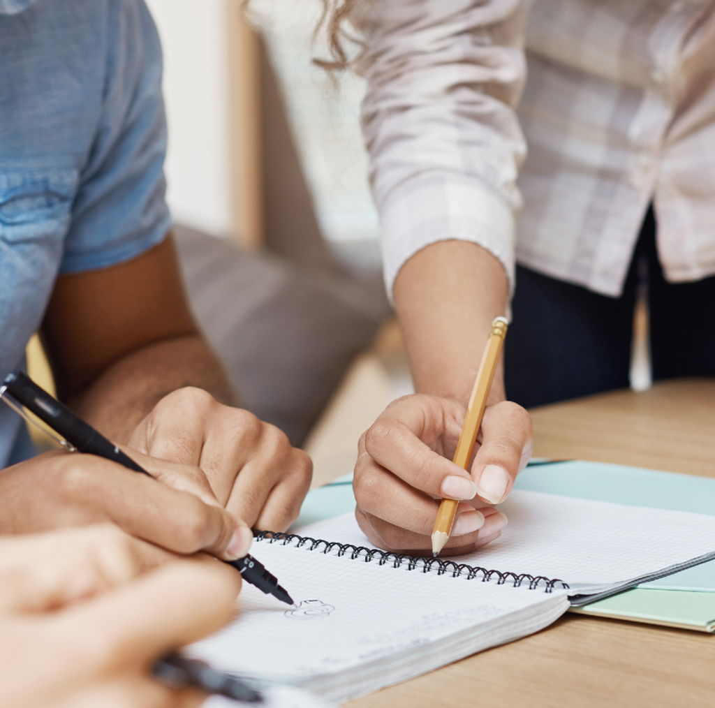 des personnes écrivent dans un cahier