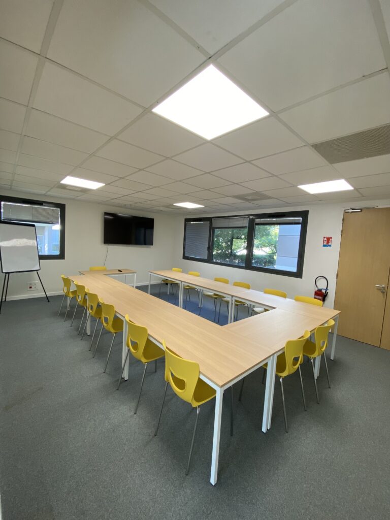 Une salle de formation en U avec un espace tableau blanc et télévision