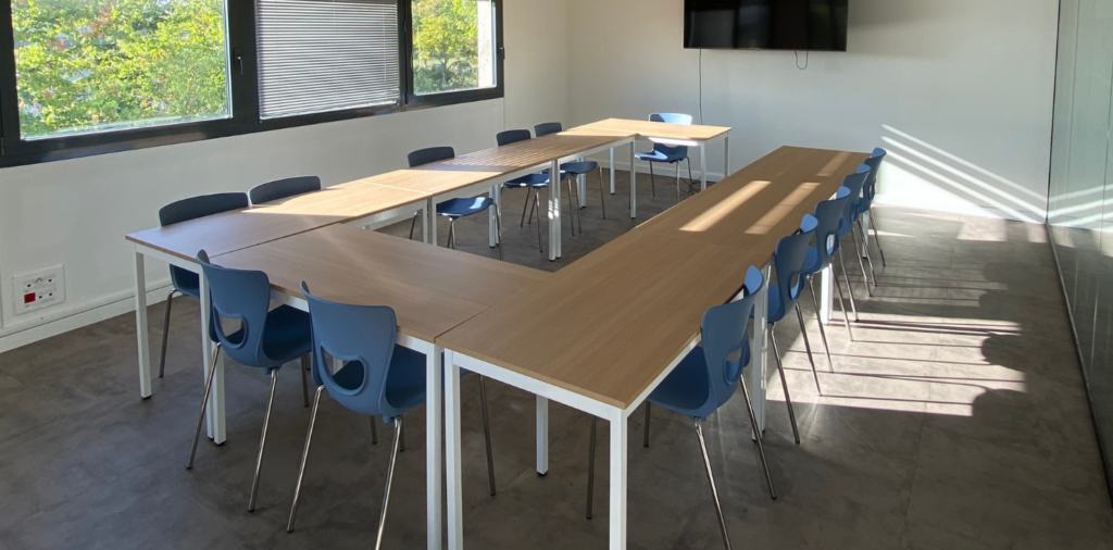 Une salle de formation en U avec un espace tableau blanc et télévision