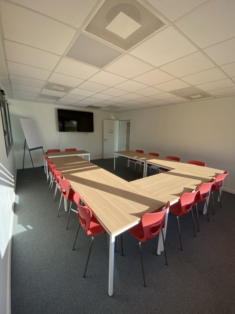 Une salle de formation en U avec un espace tableau blanc et télévision